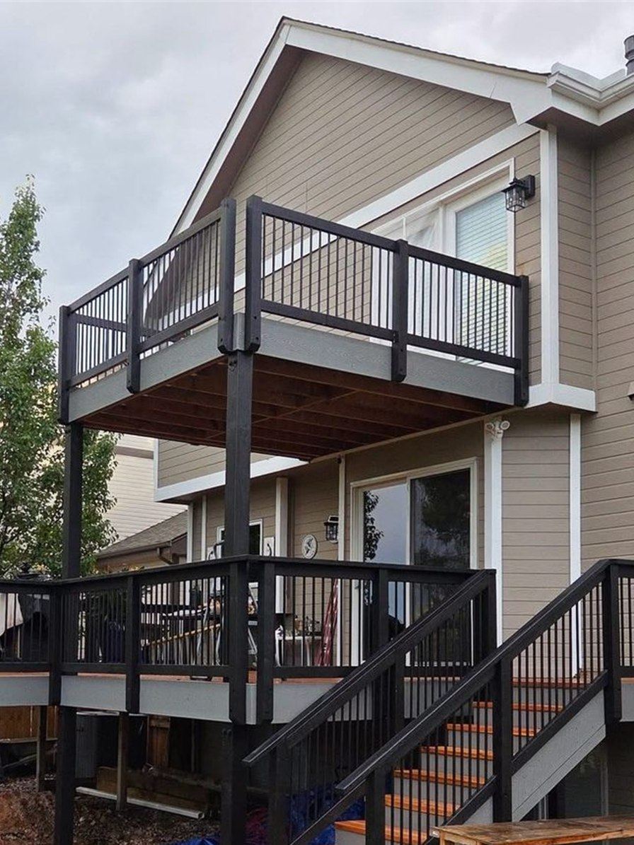 Two story deck with black railing and stairs, built by New West Co