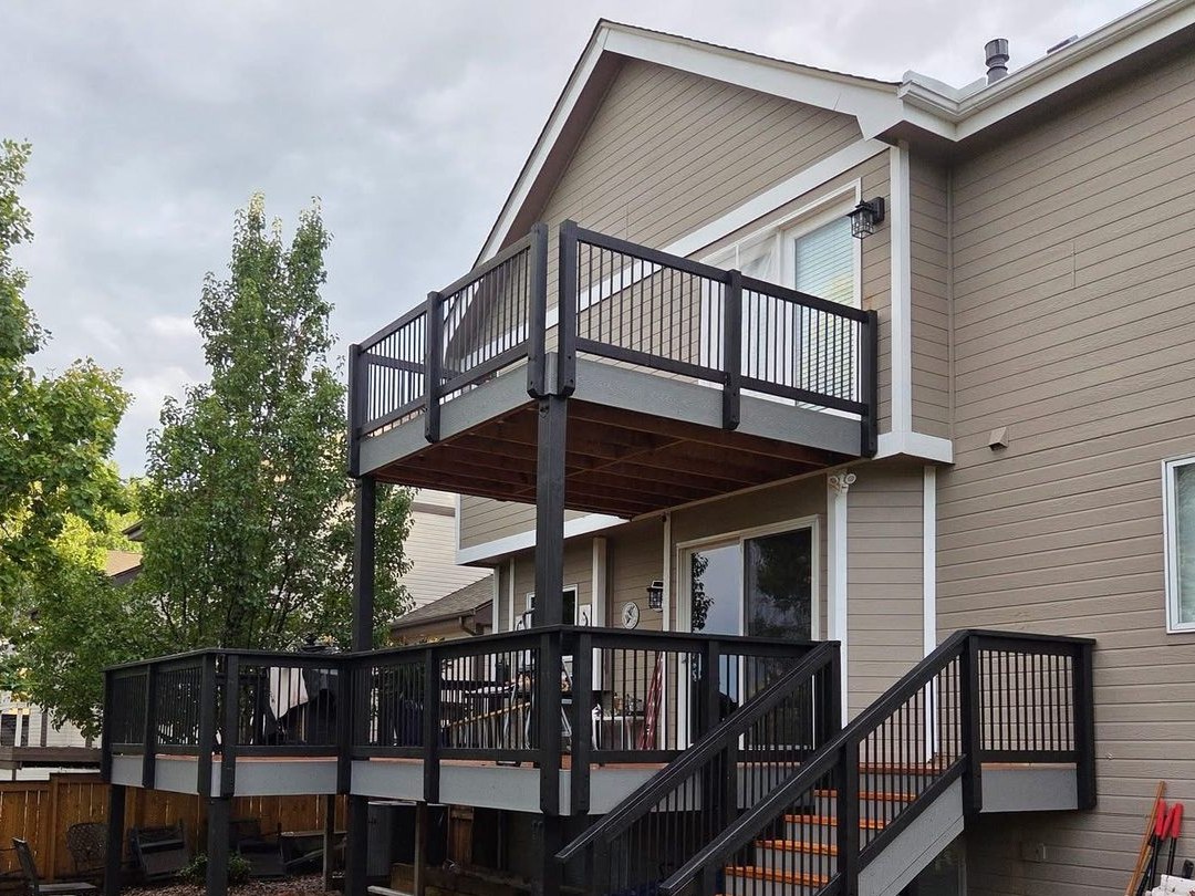 Two story deck with black railing and stairs
