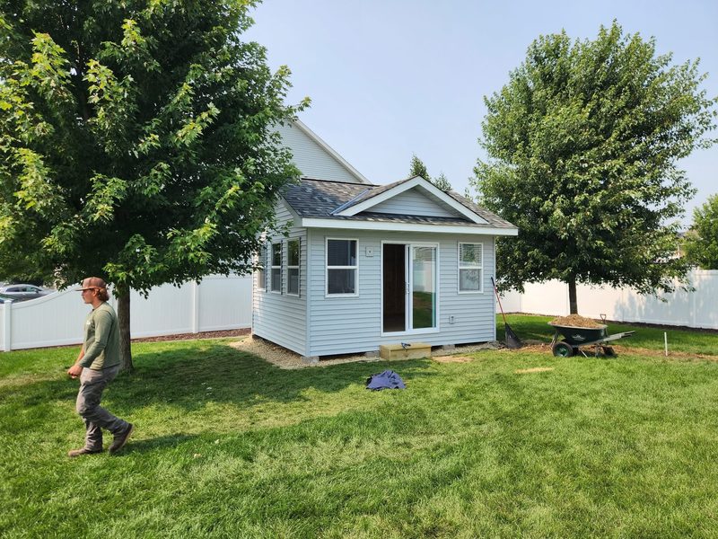 Finished backyard studio with a sliding door